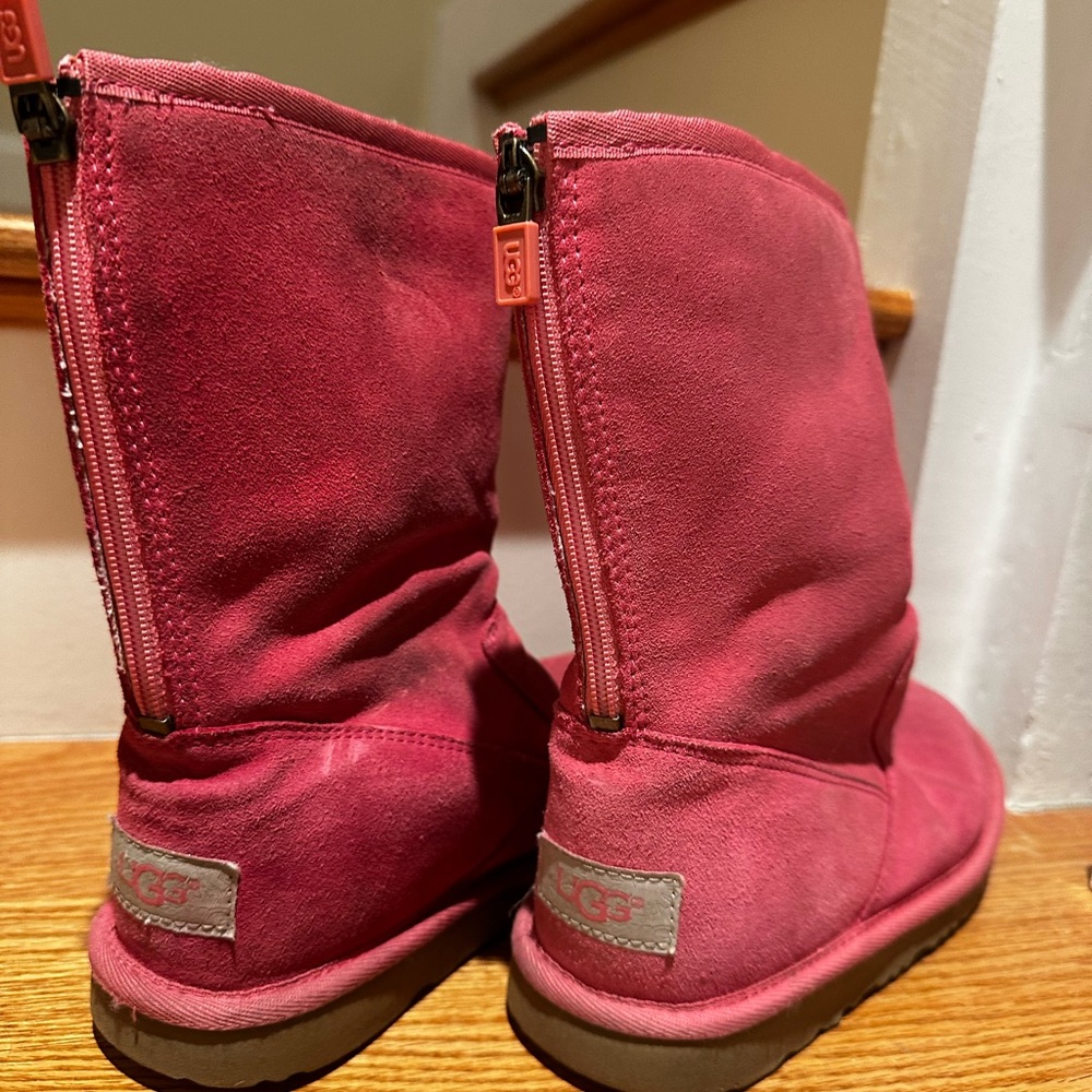Pink Ugg boots with zipper at the back.